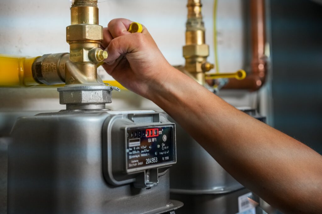 Person adjusting a gas meter to reduce gas usage - inflation, energy crisis in Europe concept